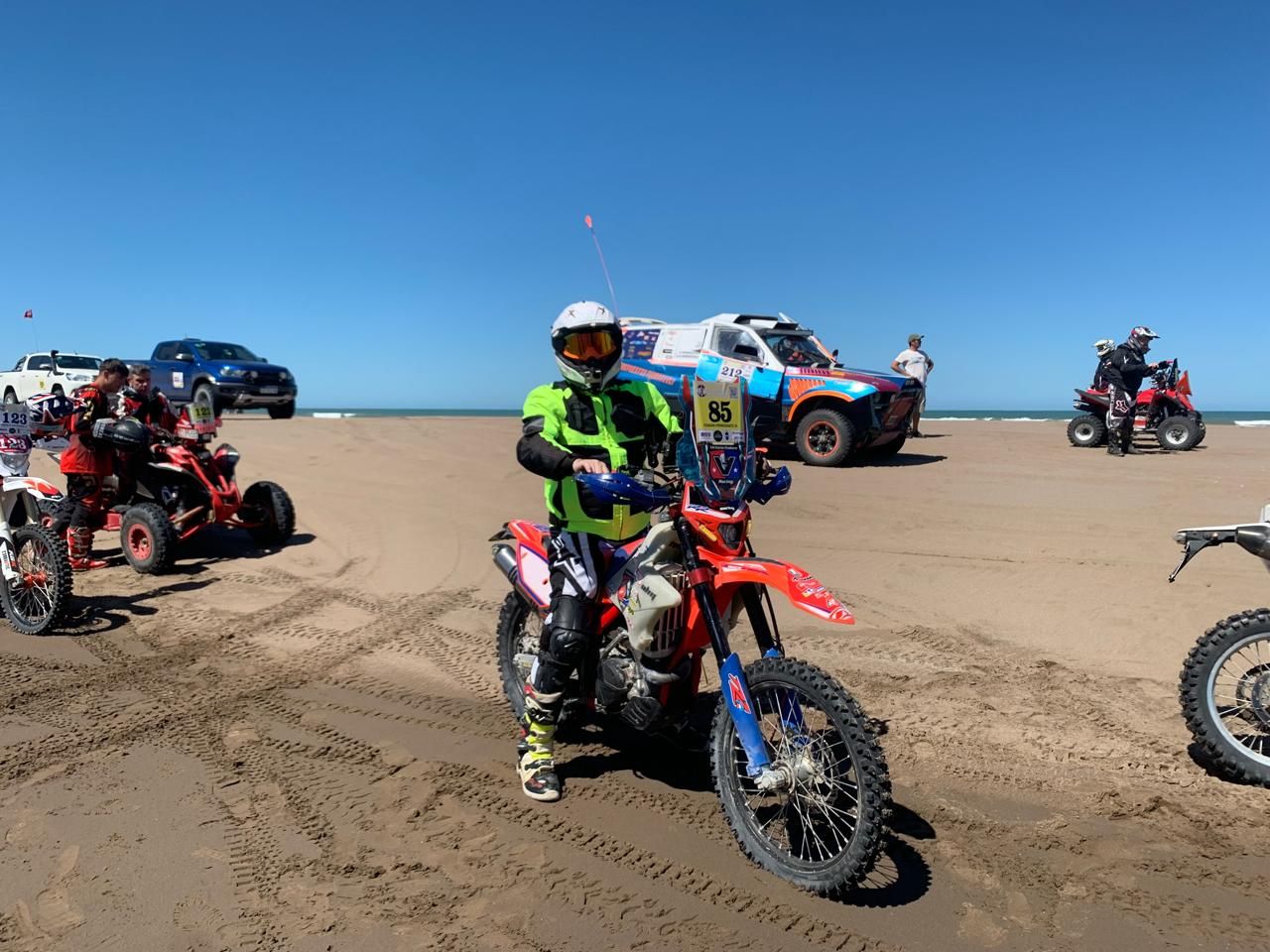 Piloto de enduro con su moto en la playa